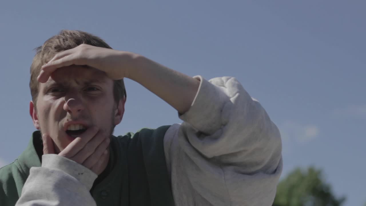 젊은 남자는 멀리서 그의 관심을 끌고 있는 무언가를 본다고 생각합니다.