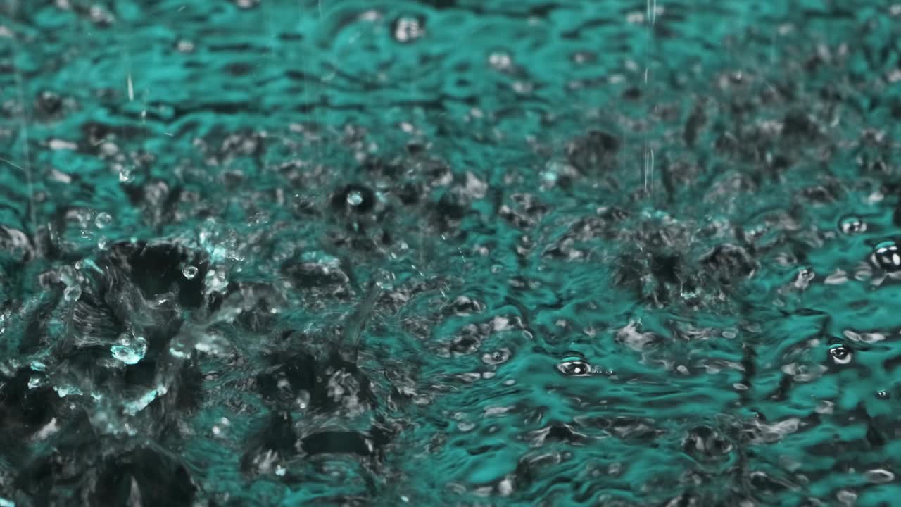 Raindrops falling in green water. Waves, ripples and bubbles on the water. Raindrops falling in green water. Waves, ripples and bubbles on the water.