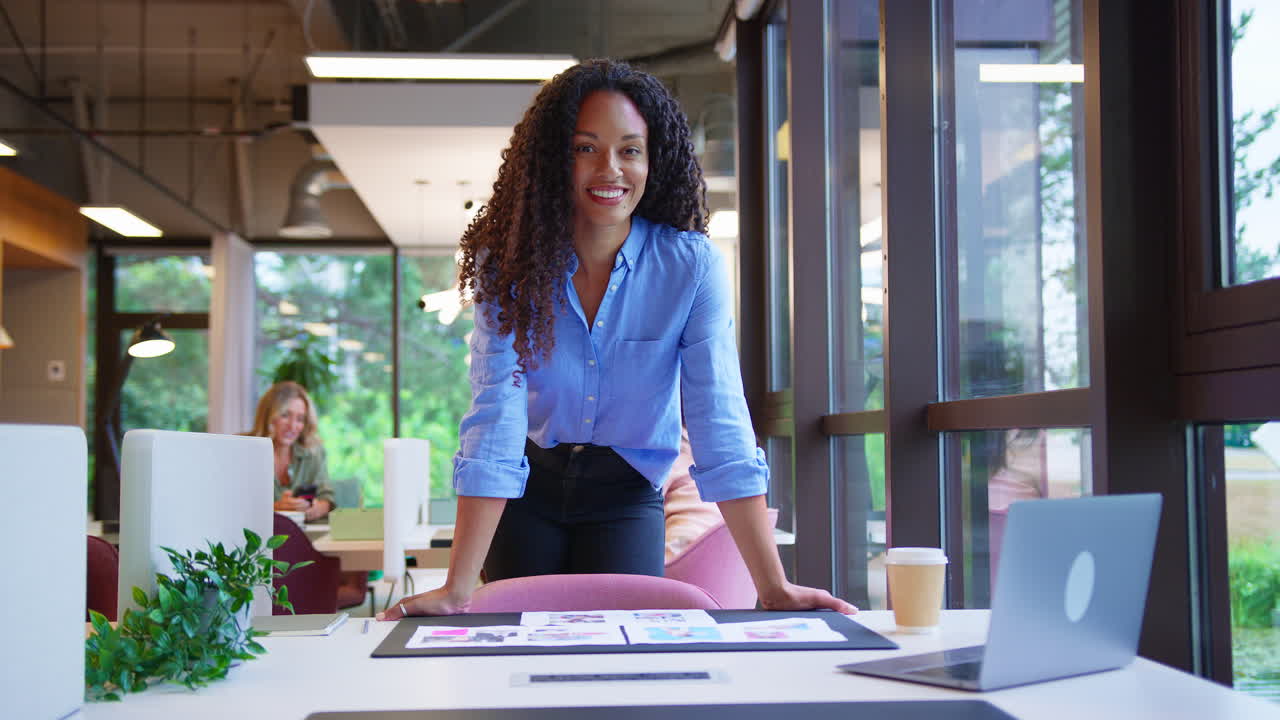 Portrait Of Businesswoman Standing At Desk In Office Approving Or Checking Proofs Or Design Layouts