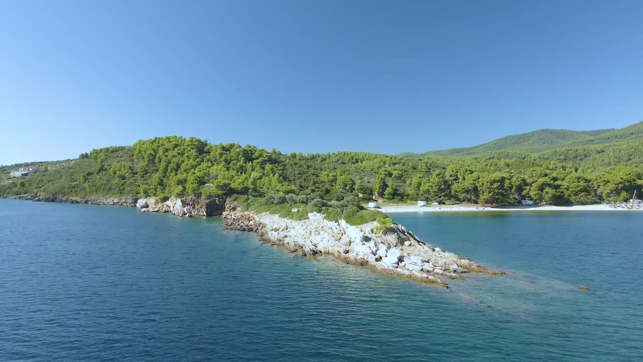 chalkidiki의 토로니의 열대 파란 물에서 바위 형성에 대한 4k 드론 클립