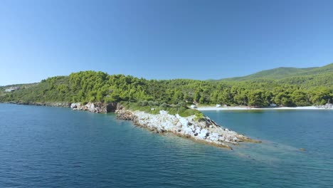 clip de drone de 4k sobre una formación rocosa en las aguas azules tropicales de toroni en chalkidiki