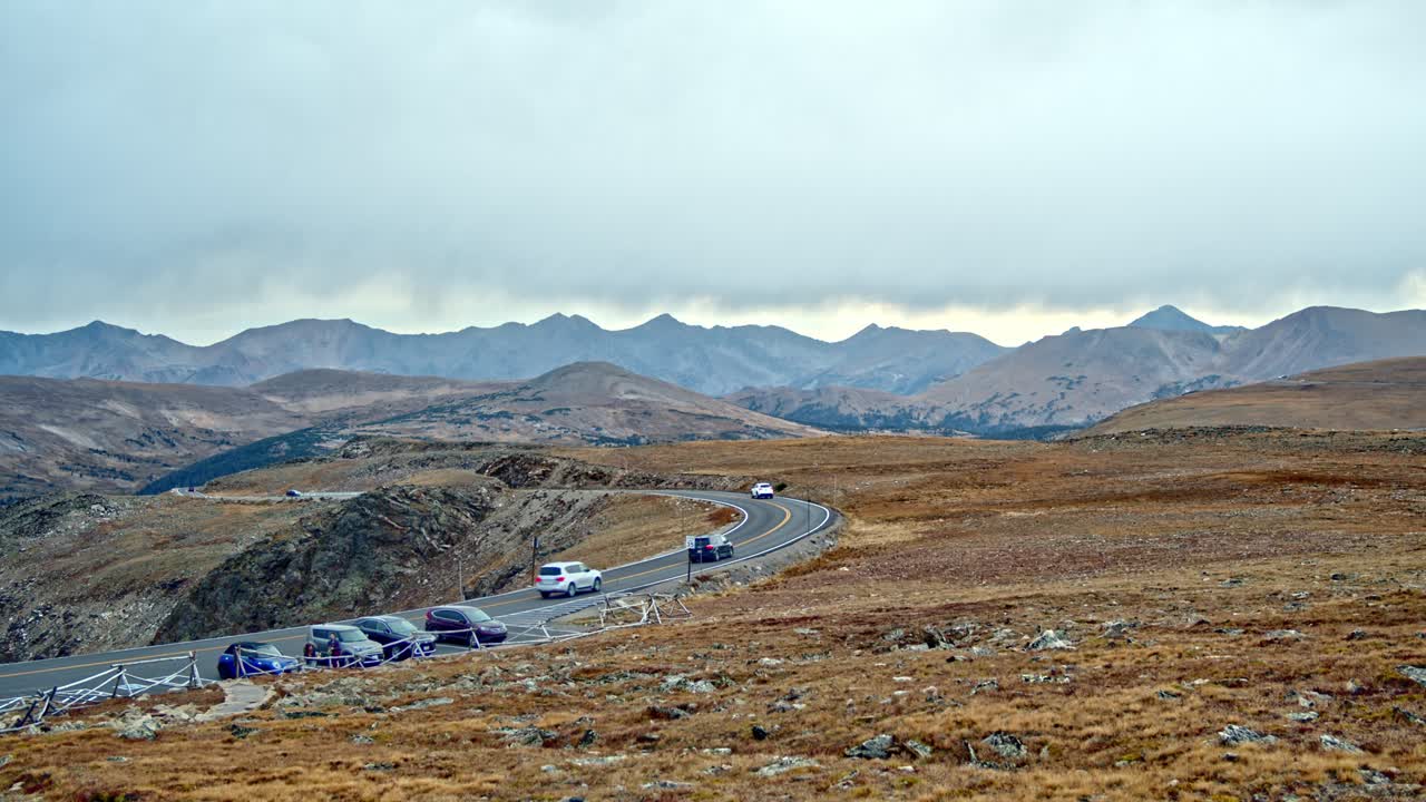 Cars and people going along a windy mountain road