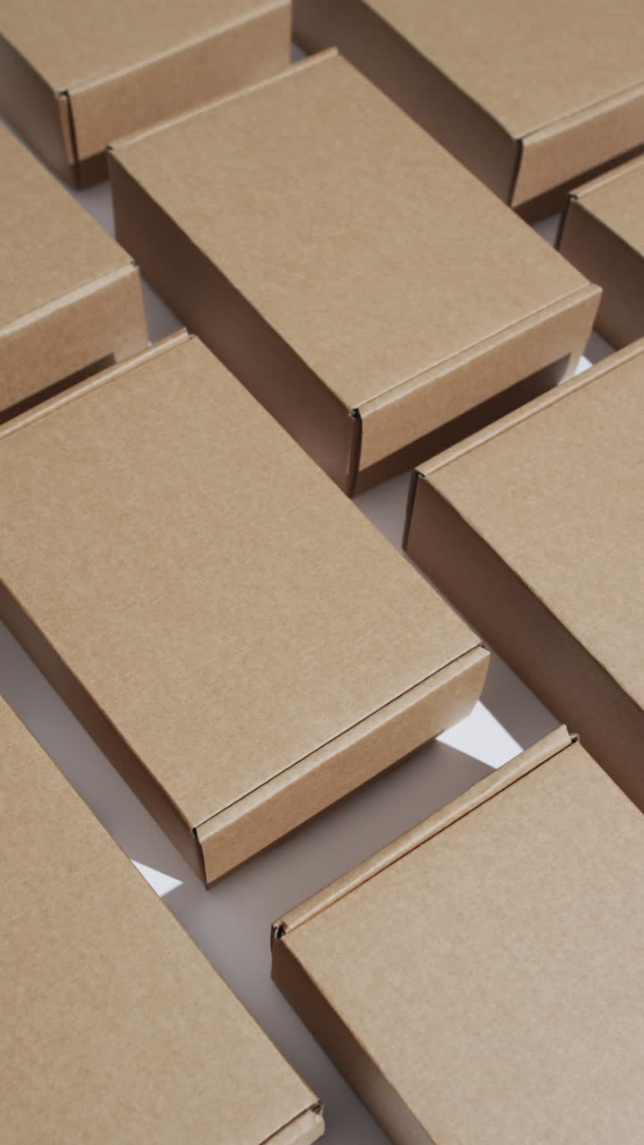Vertical video of cardboard boxes with copy space over white background