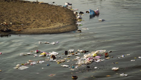 Human-garbage-polluting-the-environment,-discarded-trash-floating-in-water