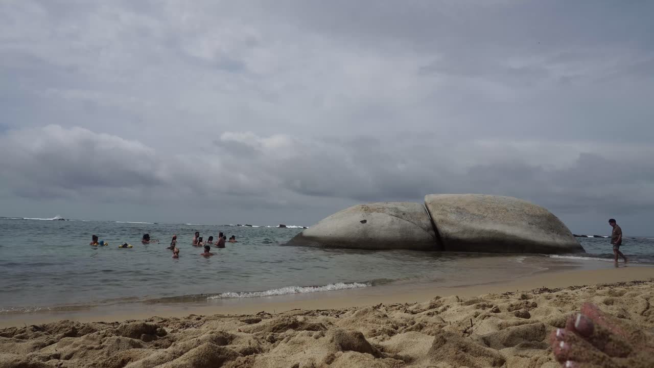 화창한 여름날 목욕하는 사람들로 가득한 해변