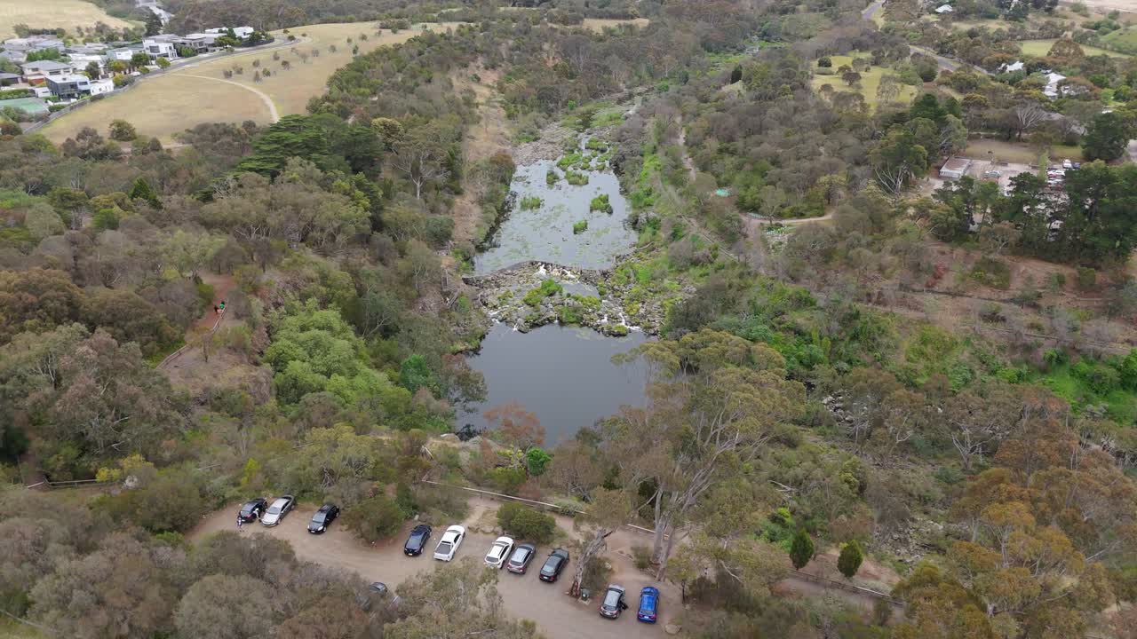 Sweeping drone view of Wulai Old Street, New Taipei City, Taiwan, featuring lush, wooded landscapes, serene roads, and residential areas under soft, diffused lighting
