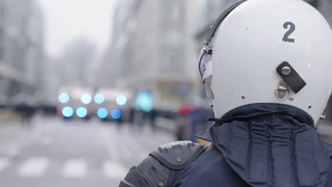 close up of police officer wearing white helmet with bokeh lights from vehicle