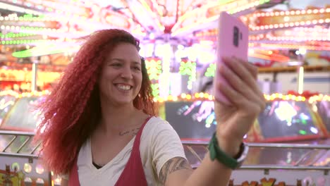 mujer de cabello rojo tomando un selfie en la feria