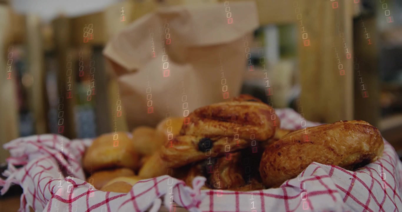 L'obiettivo si allontana, rivelando panini glassati mentre una borsa si solleva e il bokeh sfuma, mostrando il bancone.