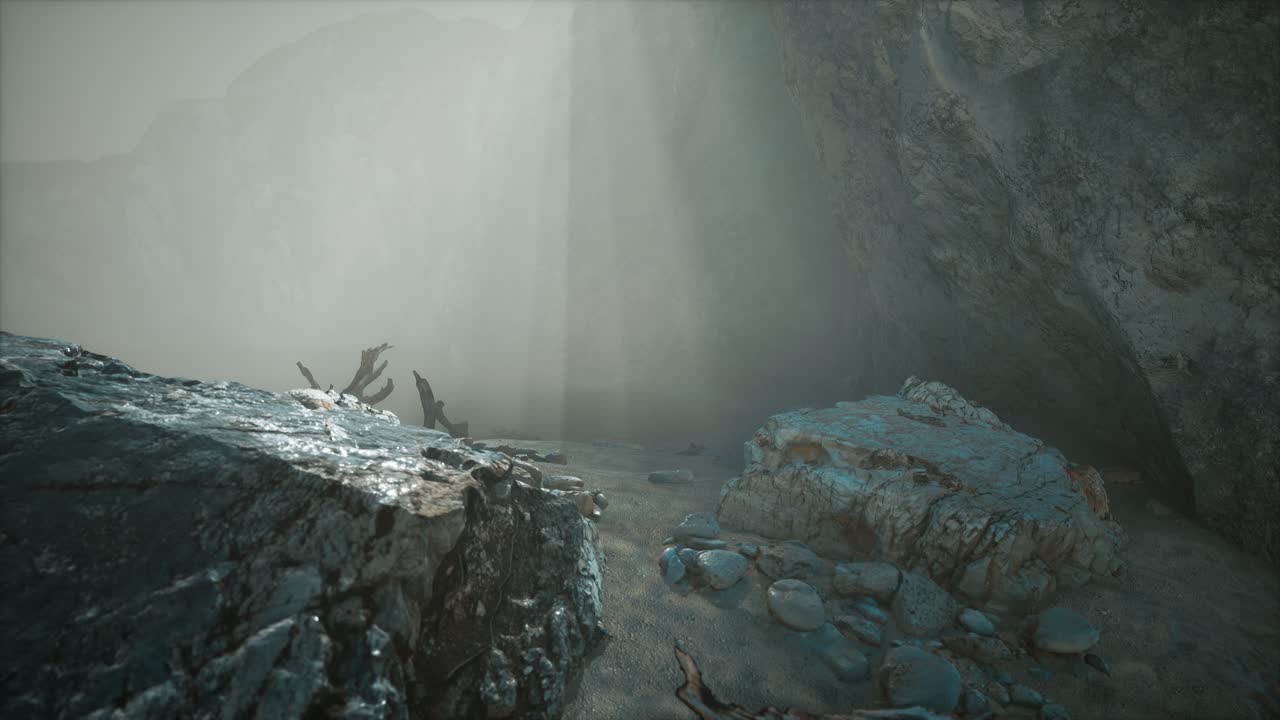 깊은 안개 속의 모래 해변과 함께 바위 절벽