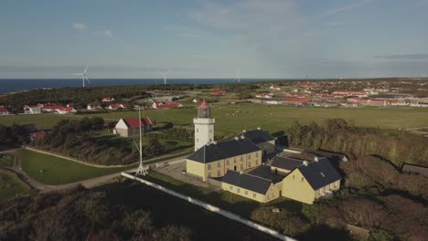 Faro-De-Hanstholm,-Thisted,-Dinamarca---Un-Exuberante-Follaje-Envuelve-El-Faro---órbita-De-Drones