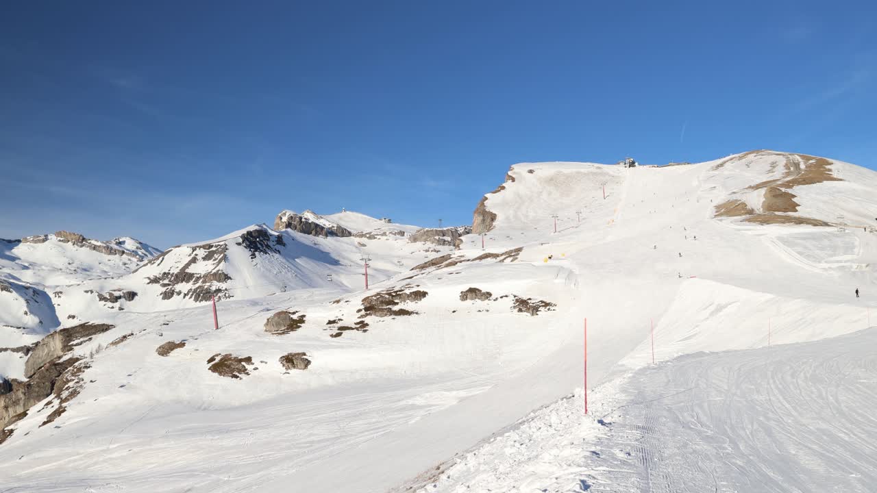 Skiers on a mountain slope with blue sky background