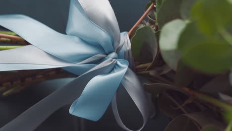 Silk-blue-ribbon-and-bow-tied-on-fresh-flower-bouquet