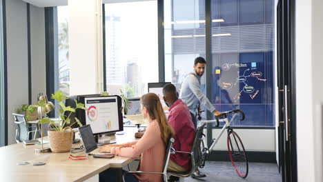 collaborating in modern office, multiracial team discussing project with charts on screen