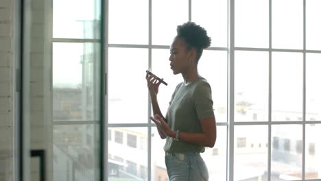 Una-Joven-Empresaria-Afroamericana-Está-Junto-A-Una-Ventana-En-Una-Habitación-Luminosa,-Con-Espacio-Para-Copiar