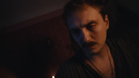 man with mustache in low light