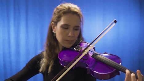 Young-musician-woman-playing-violin-on-stage.-Opera-singer,-composer.