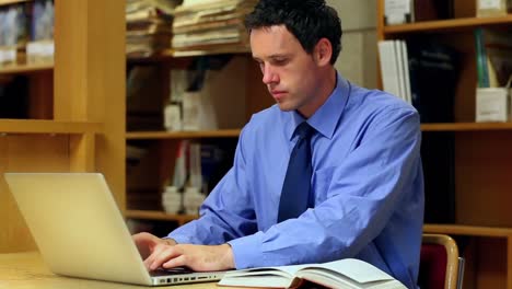 Focused-lecturer-preparing-a-class-in-the-library