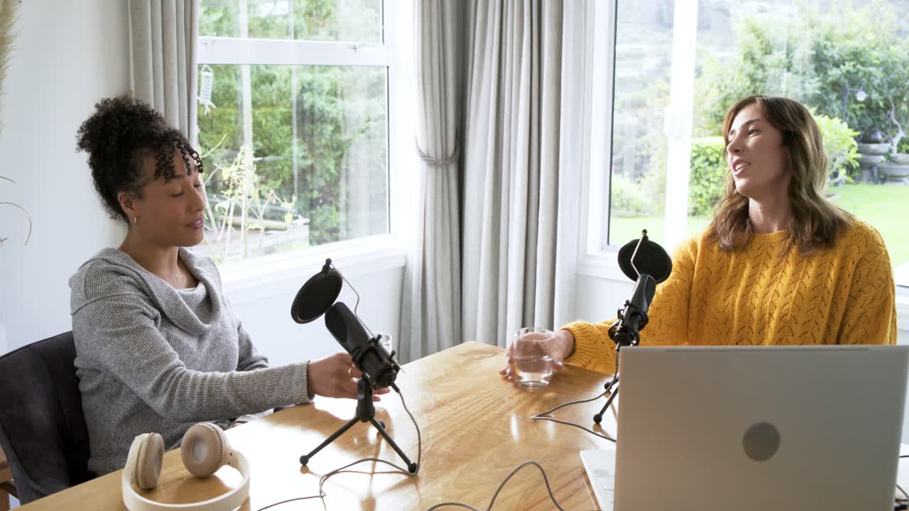 Inizio podcast: co-conduttrici cantano ai microfoni e brindano con bicchieri d'acqua.