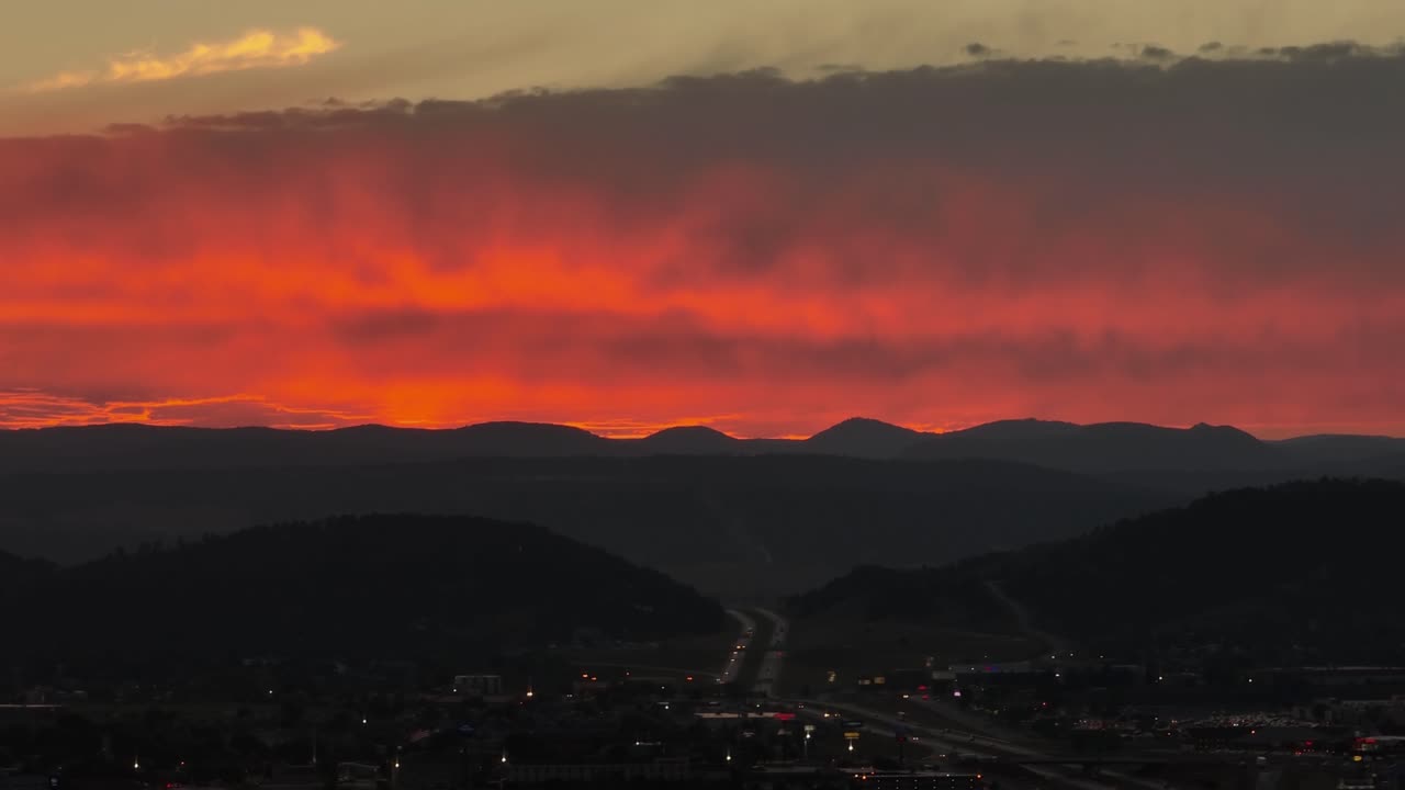 サウスダコタ州ラピッドシティに出入りする幹線道路にかかる暖かいオレンジ色の夕日の空撮