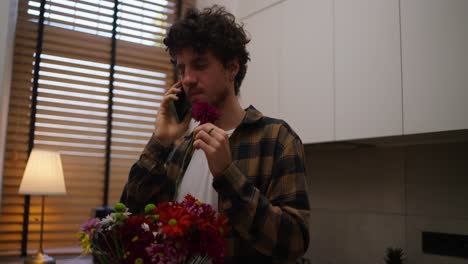 hombre hablando por teléfono y mirando flores