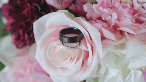 macro shot of wedding rings posed on the rose pedal leaves for a designer photo shoot