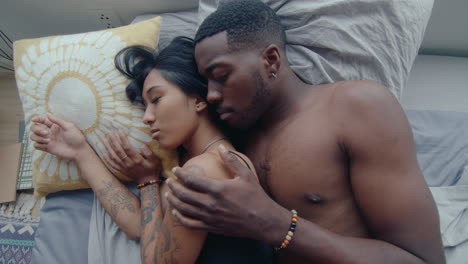 top view of young affectionate couple embracing and sleeping in bed