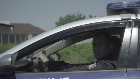 two police officers patrol in a car around the city