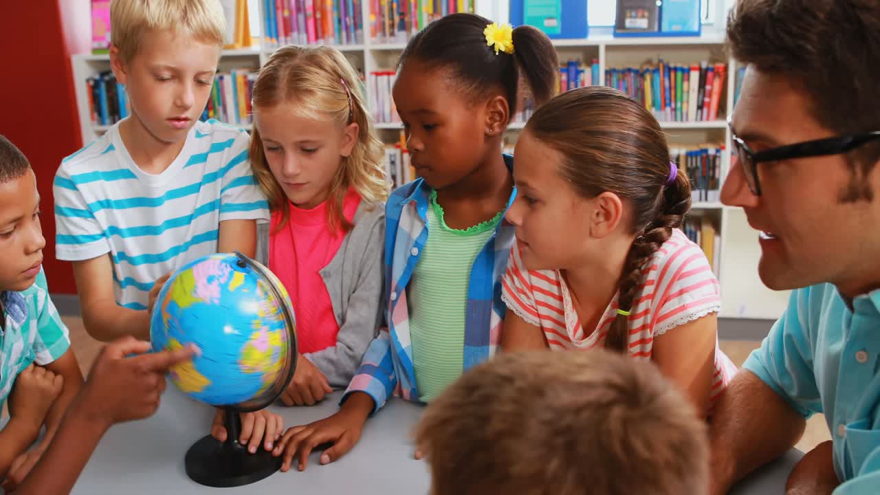 Kids and teacher looking at globe in library