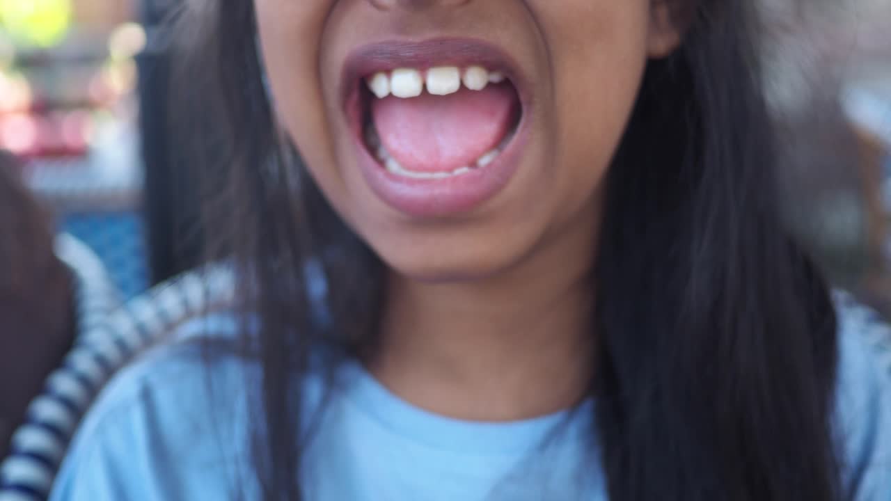 Close-up of a child's open mouth showing teeth and tongue
