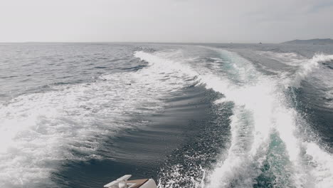 Slowmotion-Pan-right-of-the-wake-and-design-of-the-Van-Dutch-boat,-Ibiza,-Spain