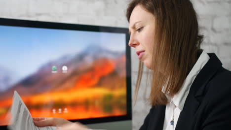 A-young-woman-stressed-and-upset-with-paperwork-and-bills-in-an-office