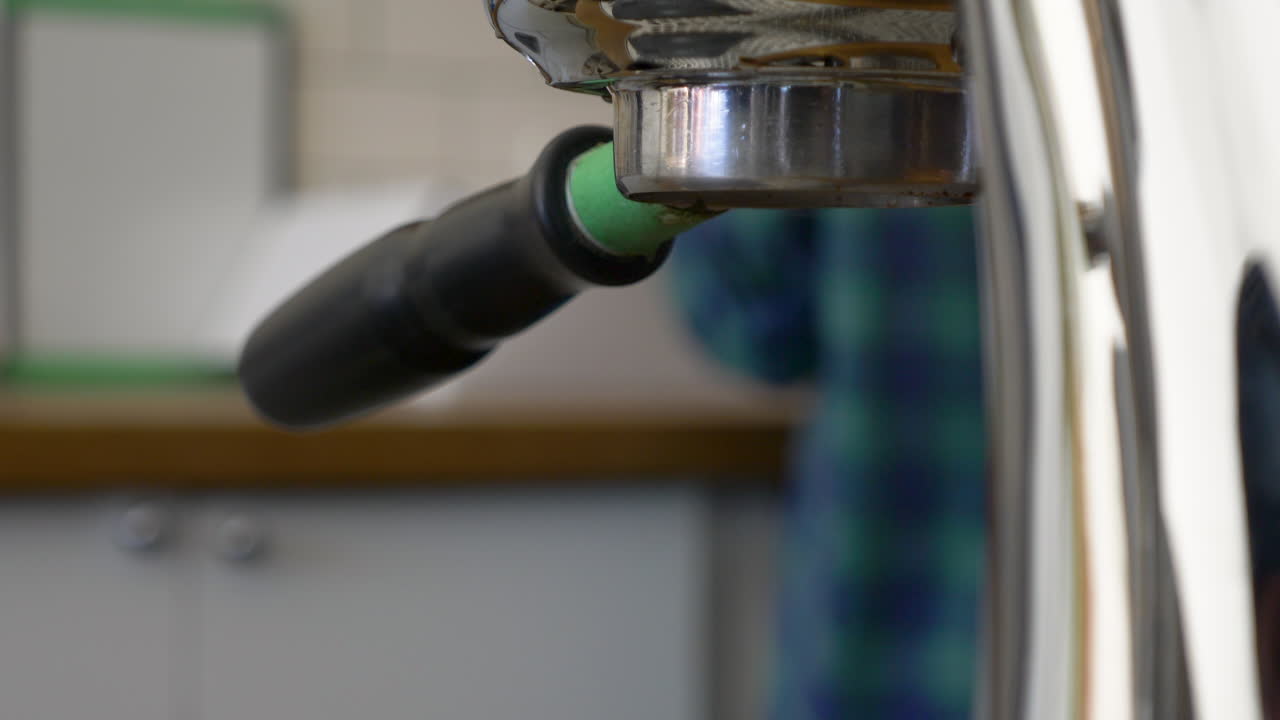 Barista che lavora con la macchina da caffè espresso dietro al bancone