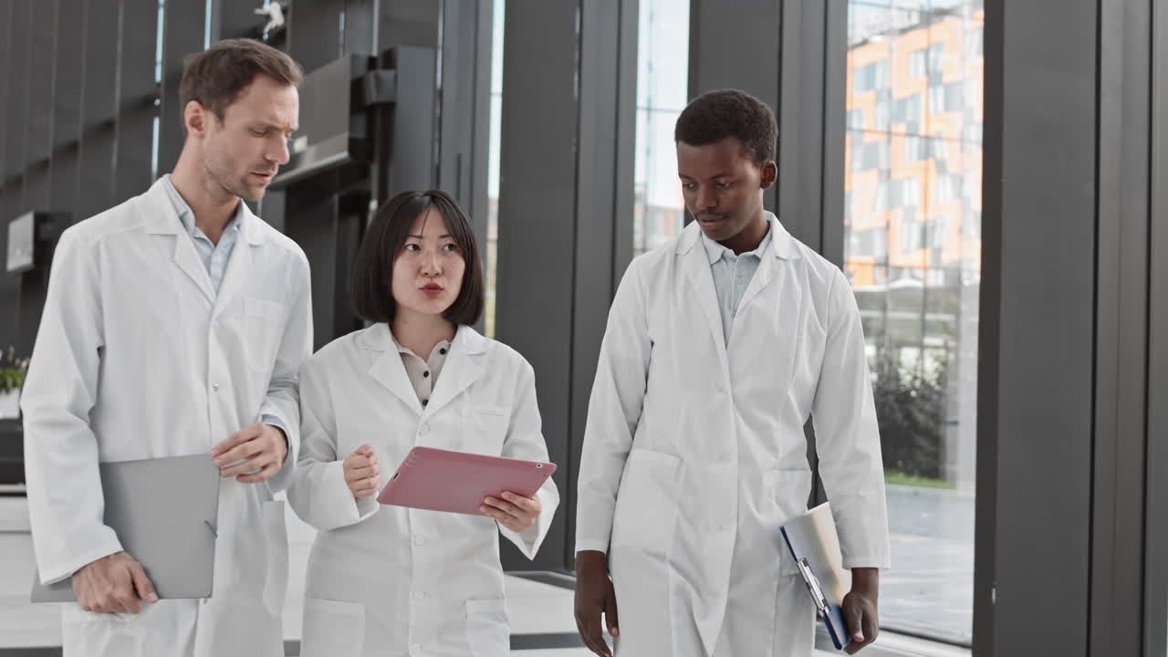 Group of Three Diverse Scientists Using Digital Tablet