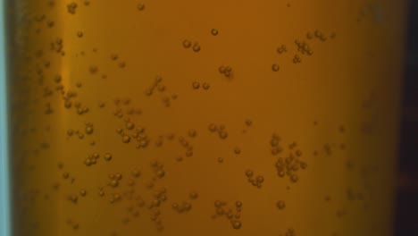 Slow-motion-of-bubbles-in-detail-adhering-to-the-glass-in-an-amber-style-beer