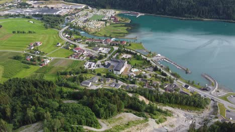 vista aérea panorámica del centro de la ciudad de loen mientras se desciende desde la montaña hoven - centro aéreo de verano que muestra el centro con edificios de fiordos y ríos - noruega