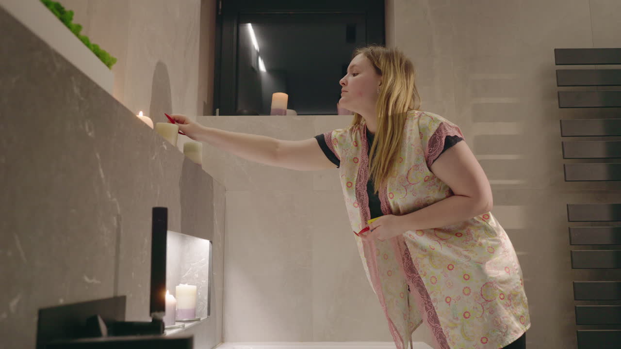 Donna che accende candele in un bagno
