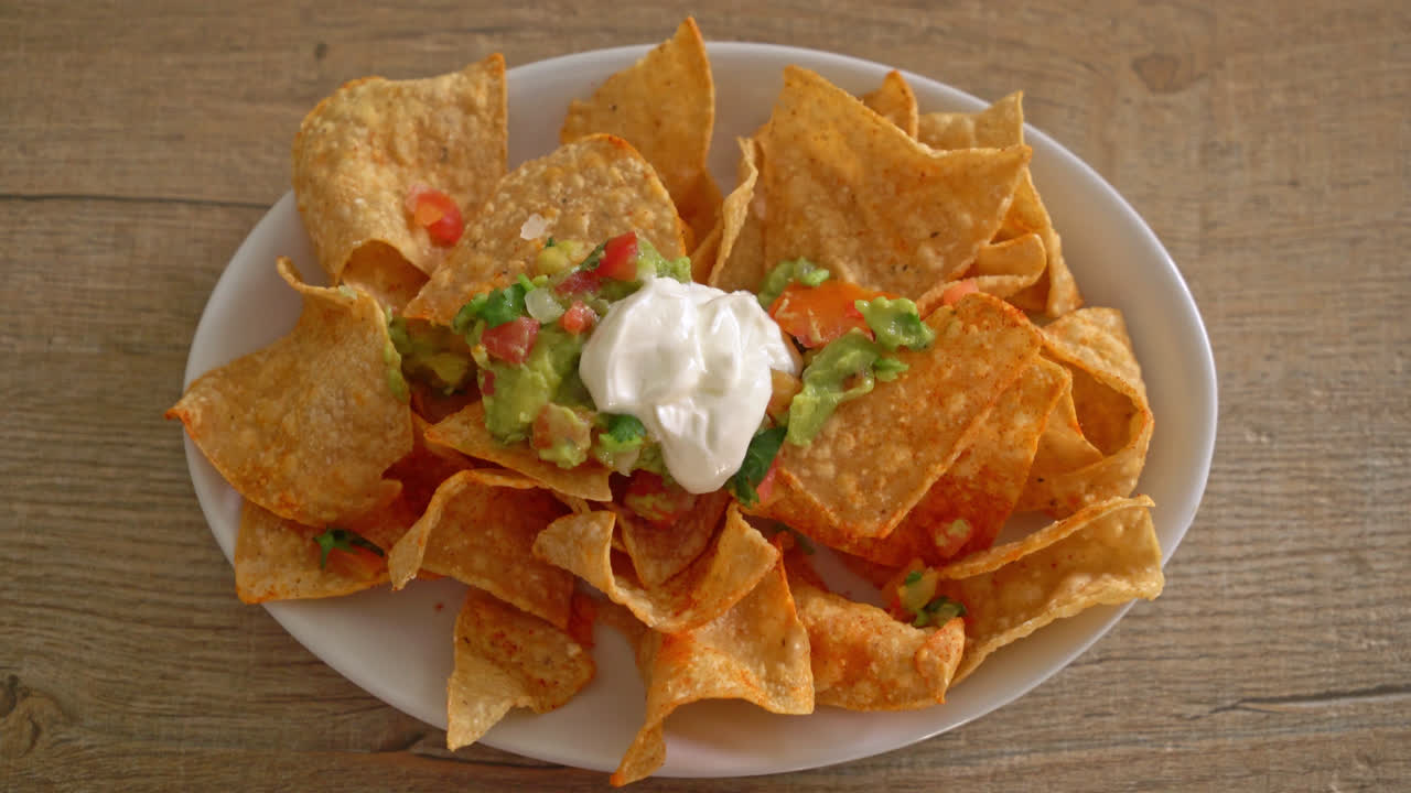 chips de tortilla de nachos mexicanos con jalapeño, guacamole, salsa de tomate y salsa