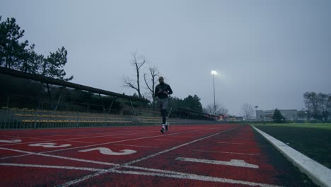 man running on a track in a stadium