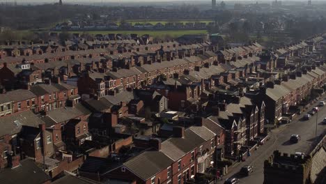 La-Vista-Aérea-Descendente-Revela-Hileras-De-Históricas-Casas-Adosadas-En-Dentons-Green,-St-Helens,-Con-Un-Largo-Camino-Que-Conduce-Al-Bullicioso-Centro-De-La-Ciudad