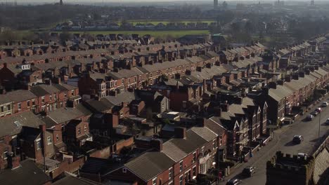 la vista aérea descendente revela hileras de históricas casas adosadas en dentons green, st helens, con un largo camino que conduce al bullicioso centro de la ciudad