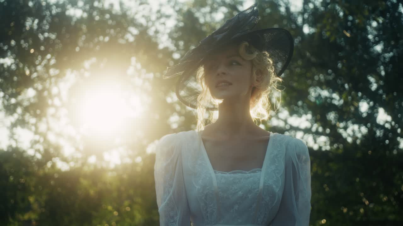 Donna elegante in abito d'epoca e cappello in controluce con la luce del sole