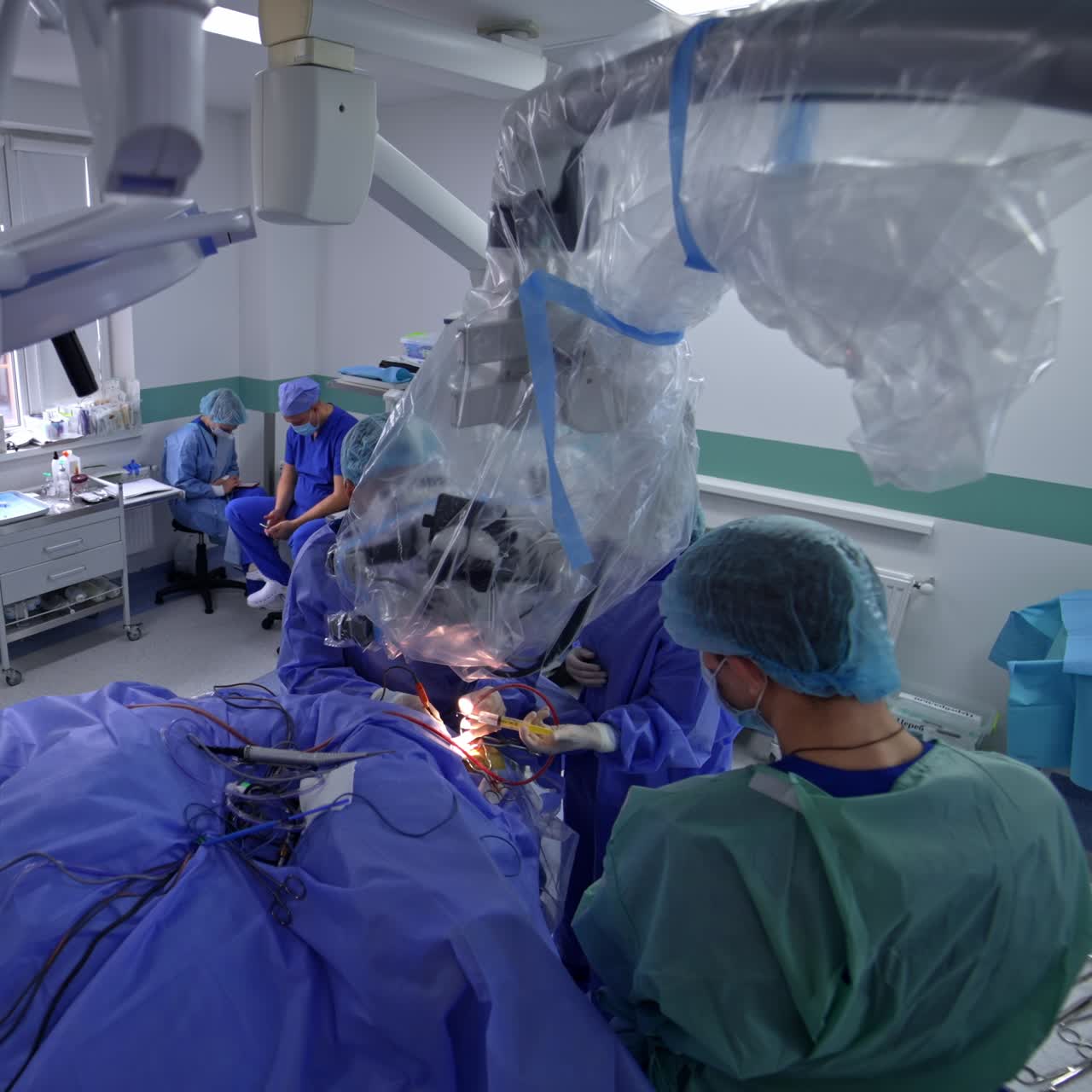 Technological equipped surgery room with operational procedure in progress. Neurosurgeon works looking at microscope. Top view