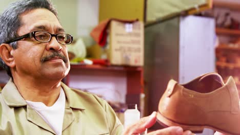 Cobbler-examining-a-shoe-in-workshop