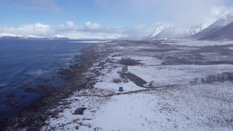 Toma-Aérea-De-Reenvío-De-Grunnfor-En-Lofoten-Durante-El-Invierno-Con-Un-Paisaje-Cubierto-De-Nieve-Y-Una-Tormenta-De-Nieve