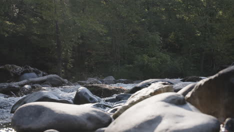 Statische-Zeitlupenaufnahmen-Von-Wasser,-Das-Im-Morgenlicht-Zwischen-Felsen-In-Einem-Bach-Rauscht