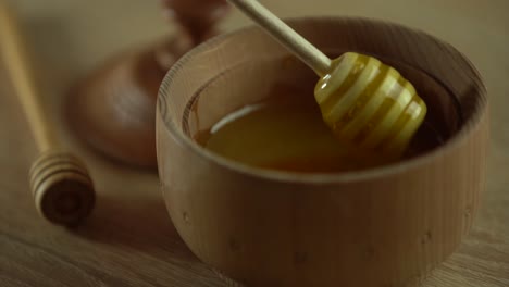 thick honey dripping from the spoon, close up. honey flowing honey from a spoon