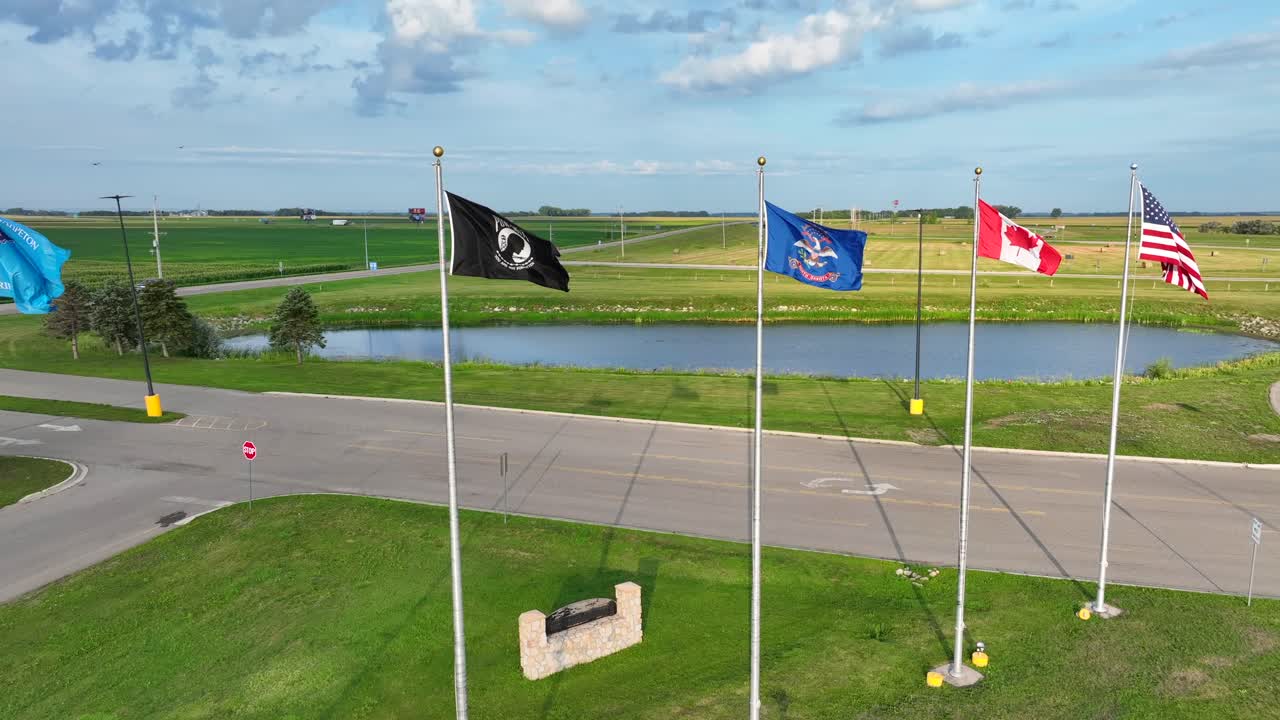 America, Canada, North Dakota, POW, and Sioux Tribe flags waving in rural settings