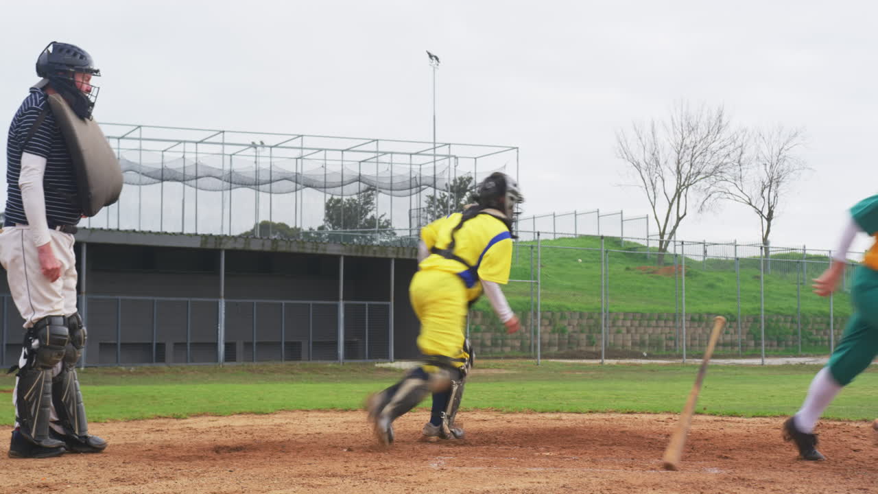 Multiracial female baseball players and male umpire, hitting the ball and running on a pitch