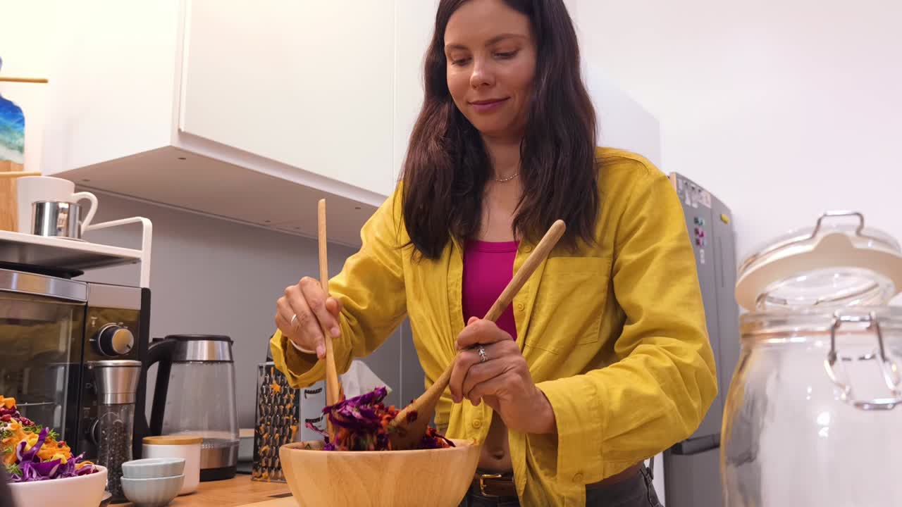 mujer preparando una ensalada saludable en una cocina